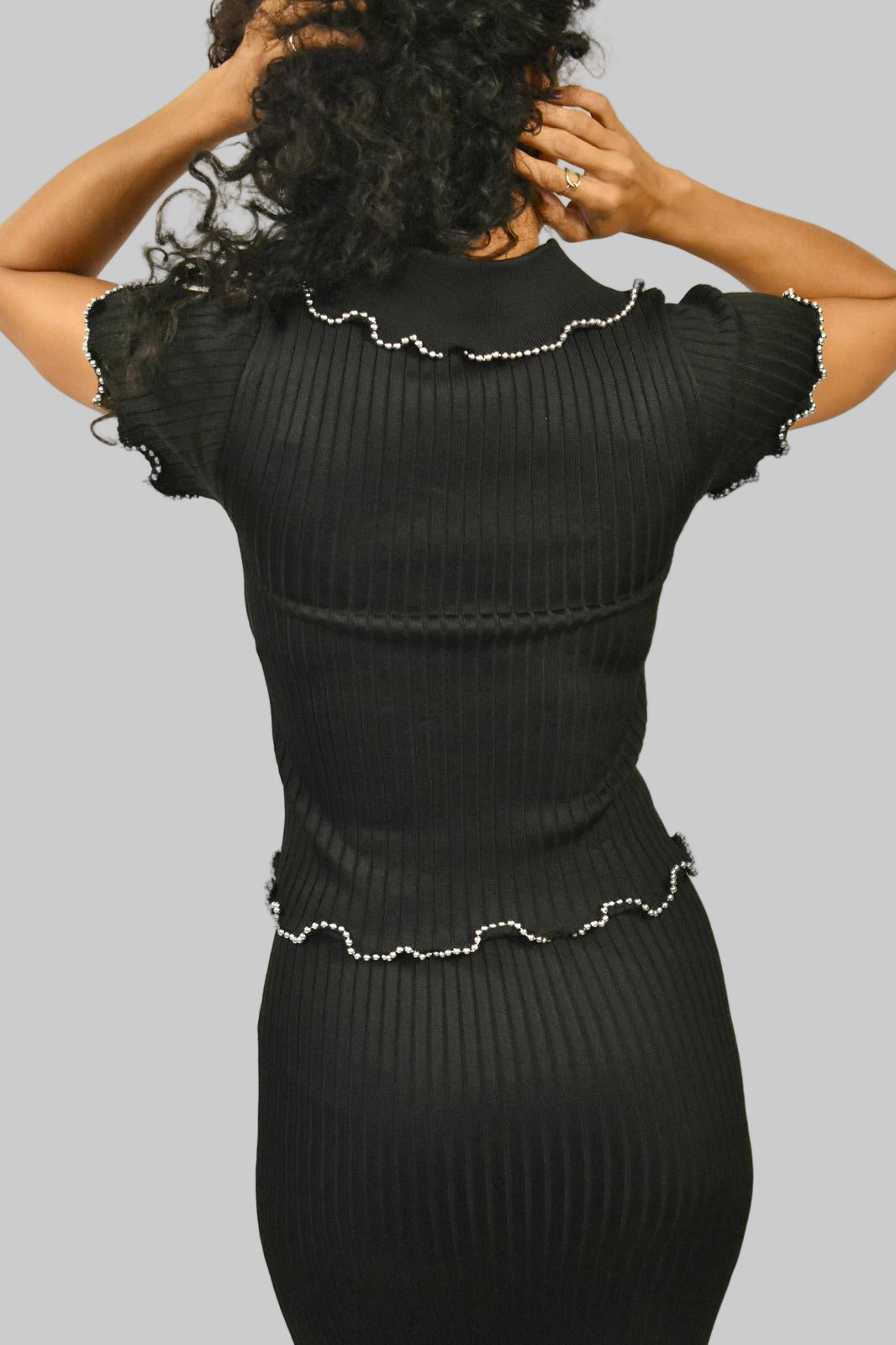 CONJUNTO DE FALDA Y SUÉTER DE PUNTO CON BORDES DE CUENTAS Y VOLANTES